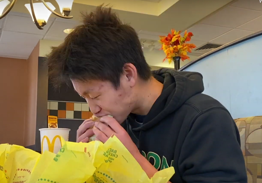 Senior Ben Zhang begins to eat his first McChicken out of eight. 
