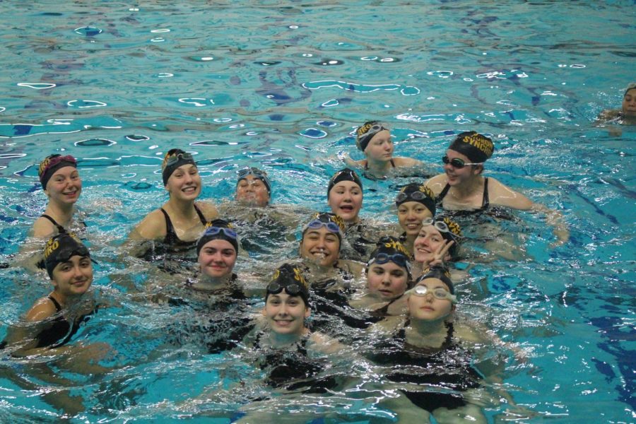 Hurons synchronized swimming team groups up to take a picture. 