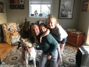 Mr. Schuitman (center) with his daughters and his dog.