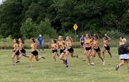 Cross country's women's team warms up for the race with short sprints.