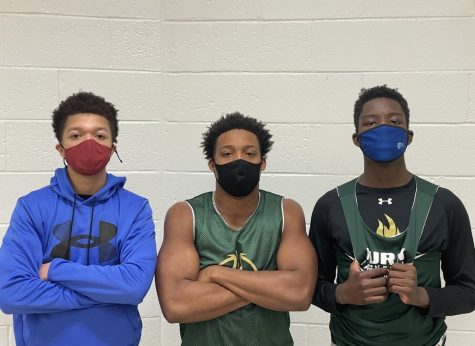 Seniors Devin Womack and Brandon Rawls and junior Jay Wambere wait to enter the gym at Huron High School. The boys play for the River Rat basketball team.