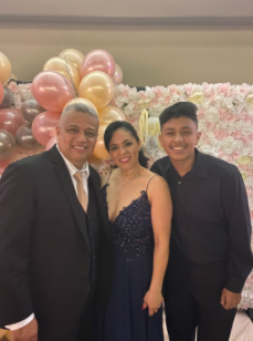 Wilmer Lazo Garcia with his mom and stepdad enjoying a quince they were at. 