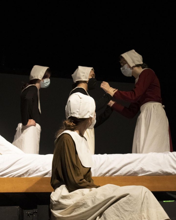 Mary Warren (front), played by freshman Audrey Hargett, and Mercy Lewis (back left), played by sophomore Lia McGovern, watch as Betty and Abigail Williams (back middle and right, respectively), played by sophomore Aria Burton-Weisman and sophomore Danny Sackett, quarrel.