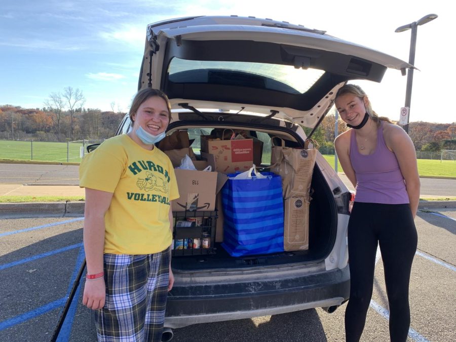 Lydia Hargett and Lorelai Sell loading up the donations received for Charity Clubs food drive to bring to Food Gatherers.