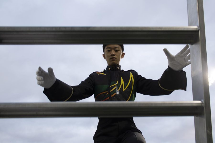 Climbing the stairs of the grandstand, junior drum major Nathan Leung prepares to lead the band at its first ever attendance of the Chelsea Invitational.