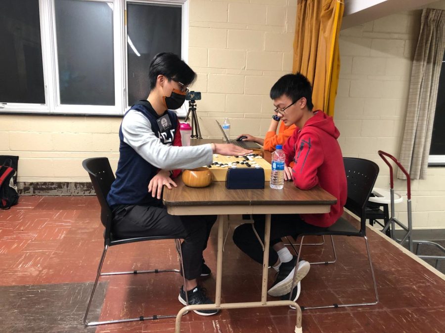 Albert Yan, left, one of the top amateur Go players in the United States, faces off against 14-year-old Alex Qi during the 2022 Chicago Go Tribute in Evanston, Illinois, on November 13th, 2022. Qi became the newest American Go Association (AGA) professional Go player during the 2022 Pro Qualifiers last July. A ferocious fight has erupted on the bottom left of the board as the clock ticks down. Yan, playing black is on the offensive. 