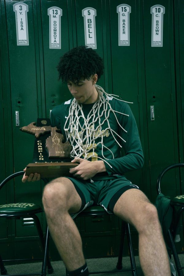 Senior TJ Bell poses with the district title trophy. Bell had 9 points in Hurons win over Pioneer.