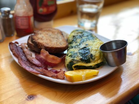 The Vibrant Veggie Omelet comes with a side of bacon, multi-grain toast, and raspberry jam. 