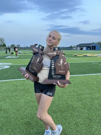 Overgaard posing with two MHSAA trophies. Photo courtesy of Overgaard