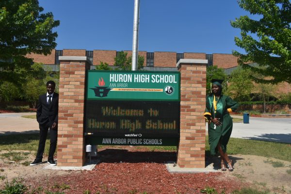 Marriam Nassuna (right) and her brother (left) pose in front of Huron High School, May 31, 2023. Photo courtesy of Huron High School.
