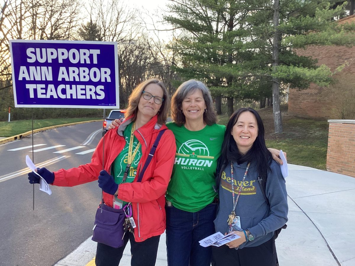 Kathryn Jones, Kelly Van Ee, and Martha Hale protesting near the bus drive. 