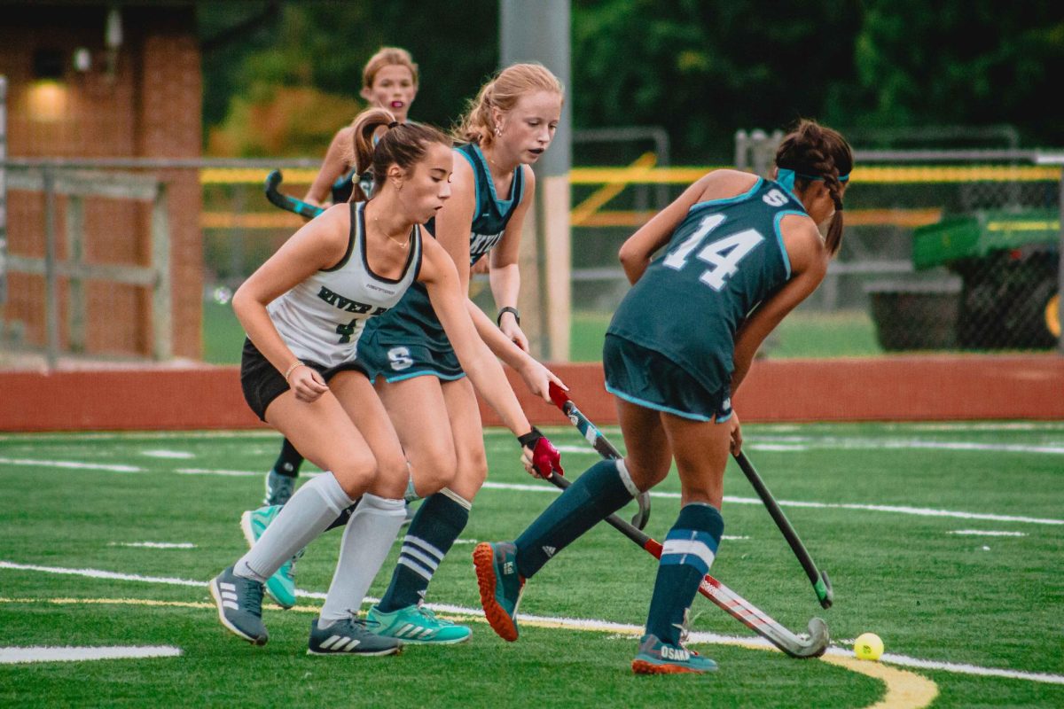 Senior Emmie Southam attempts to gain control over the ball between the Skyline players.