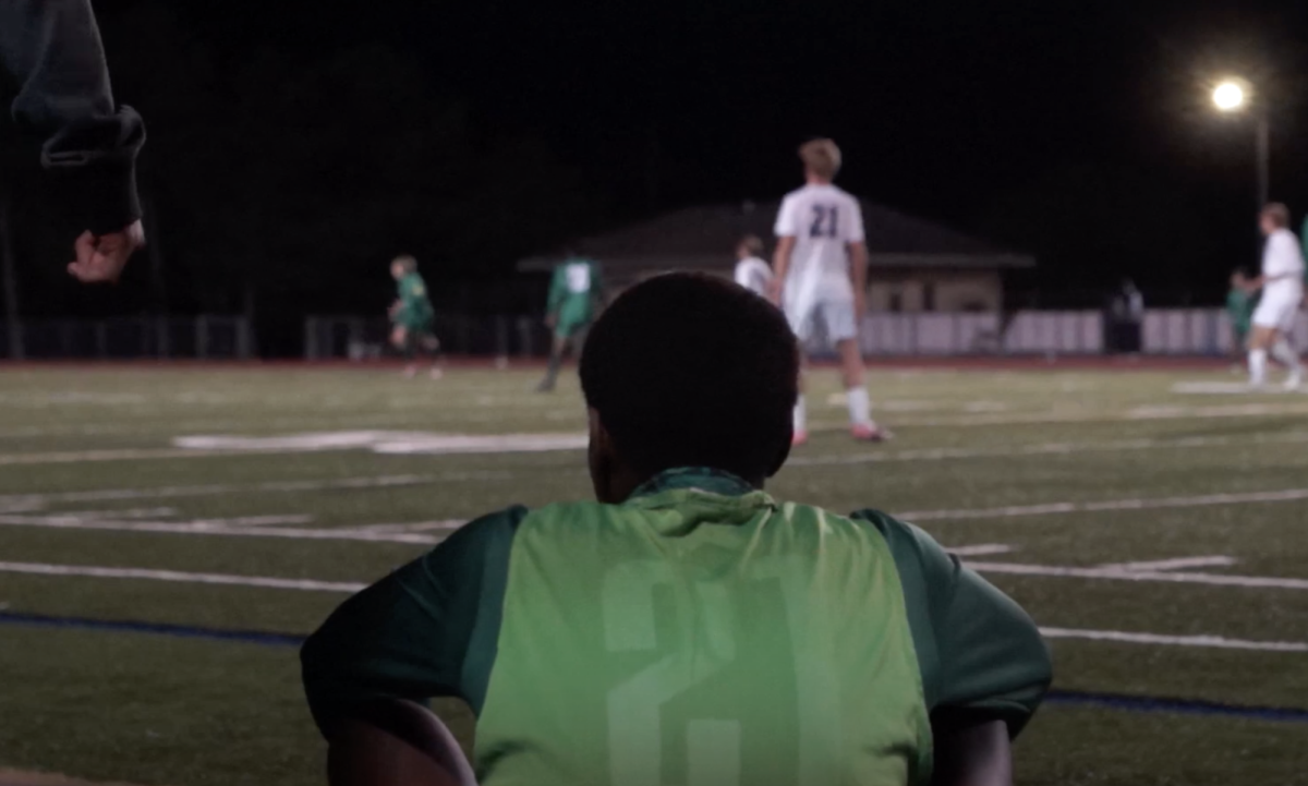 Junior Amadou Sidibe sitting on the turf as Huron and Clarkston battles on the field. 