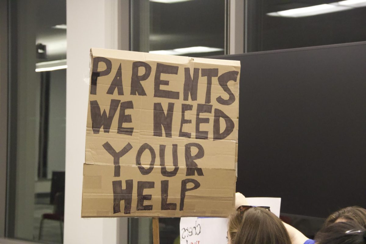 AAPS community members held a rally before the School Board meeting on Wednesday to protest the rising healthcare costs for teachers.