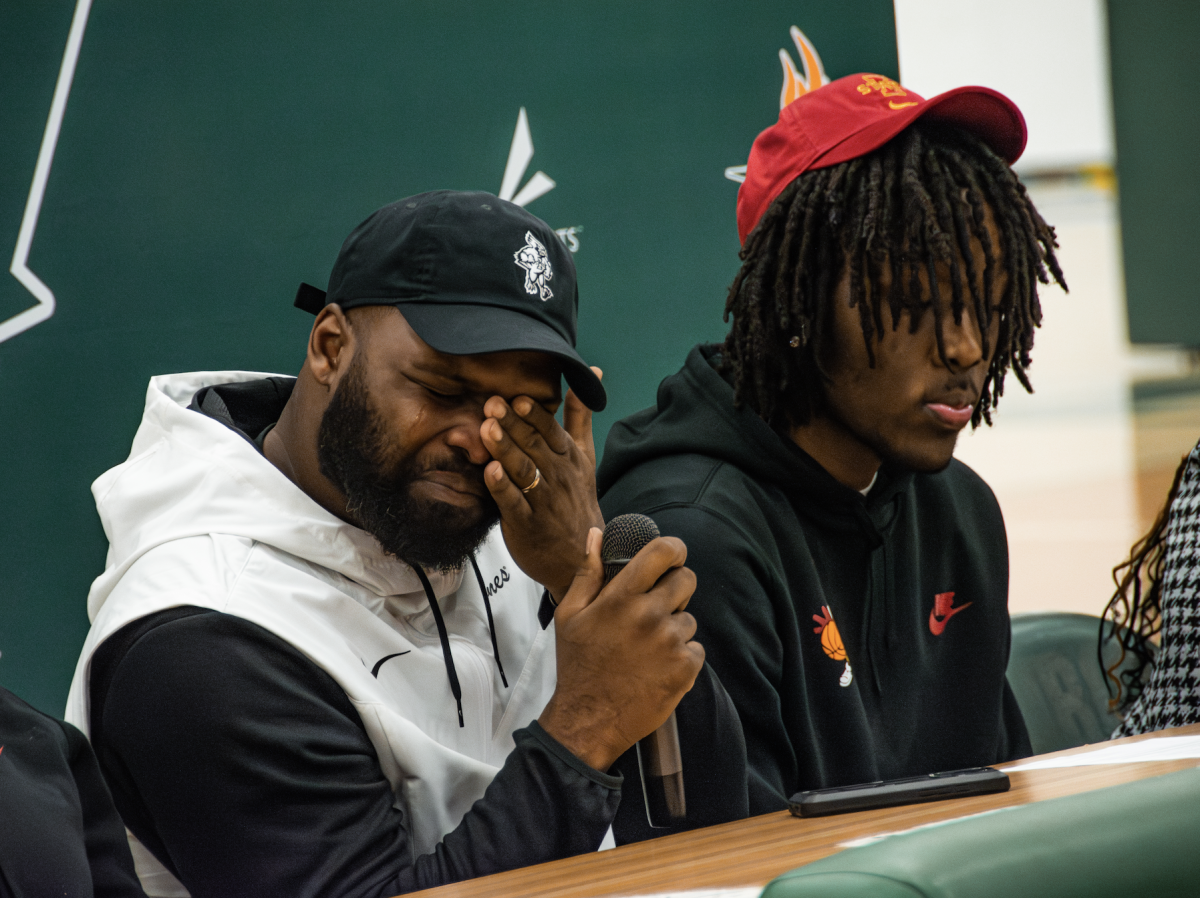 Emotional and deeply proud, Macari Moore's father sits with Moore during the big moment. Photo in courtesy of Ryan Bezas.