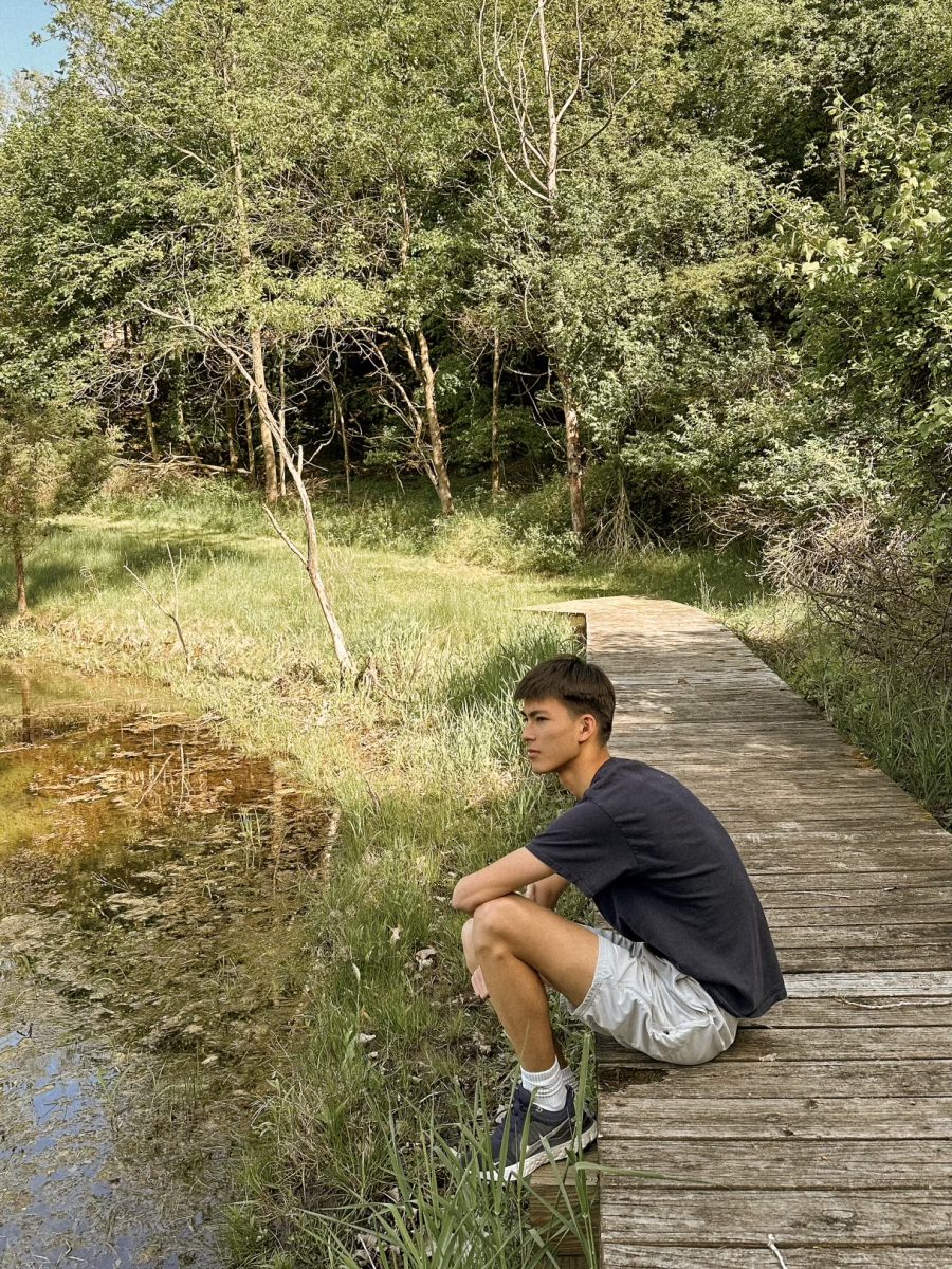 Senior Trevor Nelson sitting by a pond in his backyard. Courtesy of Trevor Nelson.
