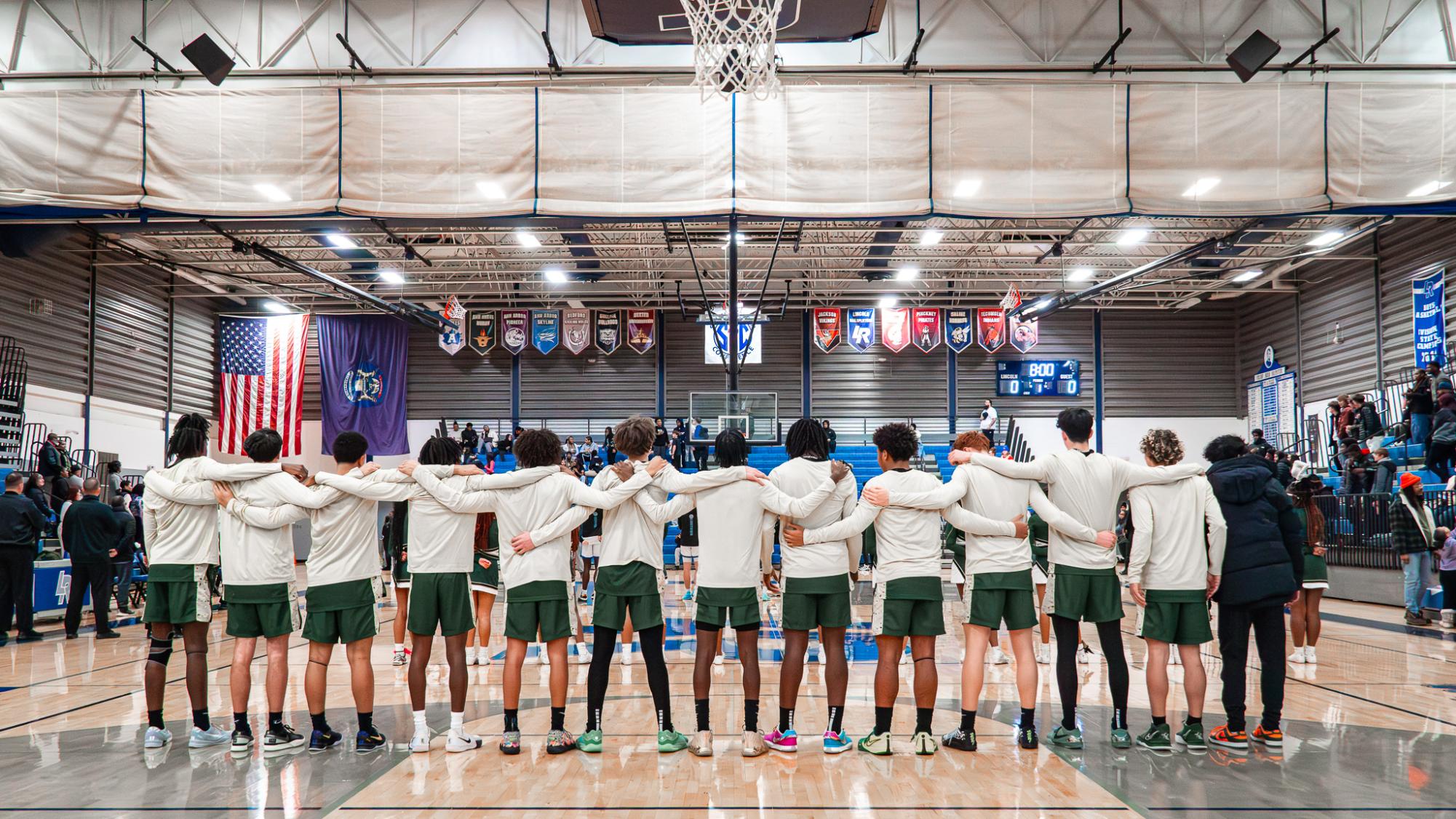 The Huron team stands in united as the national anthem echoes throughout the Lincoln gym.