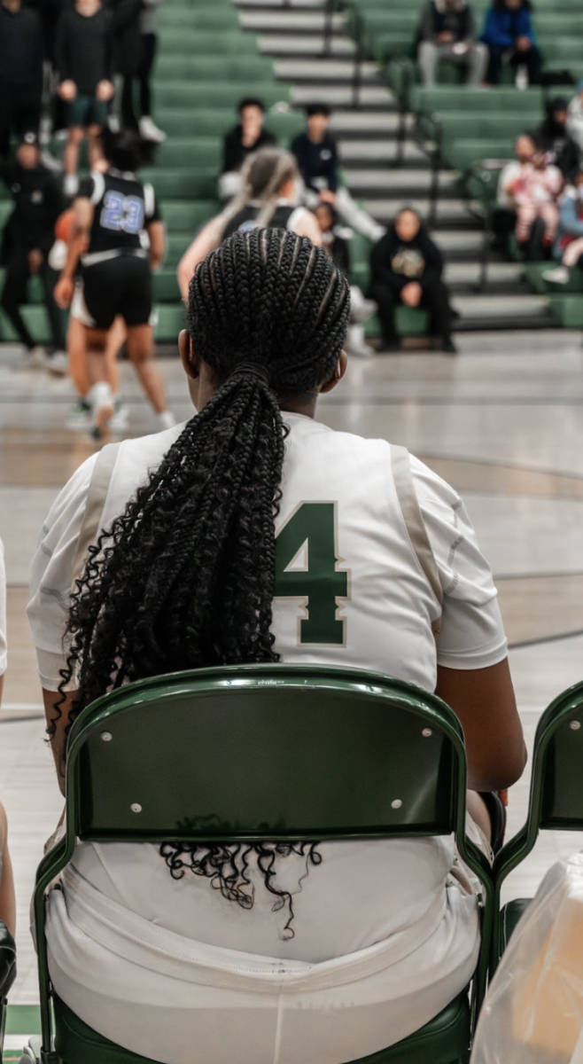 Junior Legacy Robertson cheers on her teammates from the bench as she takes a break and waits to get back into the game.