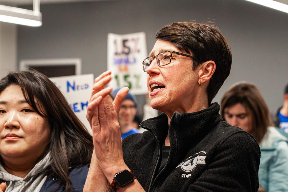 Angell Elementary teacher Anne Ward claps with the crowd protesting healthcare increases at a School Board meeting on Jan. 29.