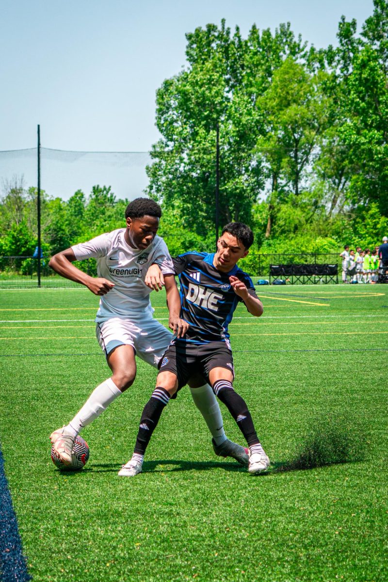 Junior Amadou Sidibe tries to conserve the ball as the opponent pressures him.