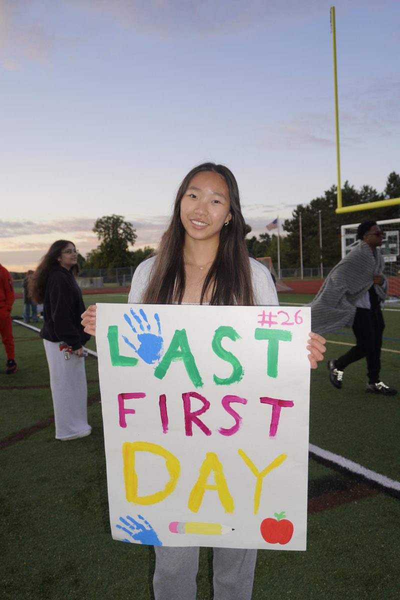 Senior Catherine Huang holds up a sign reading “Last First Day,” marking the milestone of her final year.