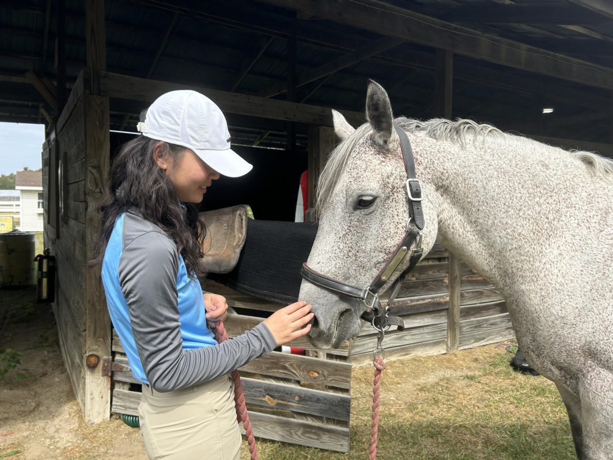 Senior Elizabeth Bang with her Skyline riding horse, Wisteria, on a game day.