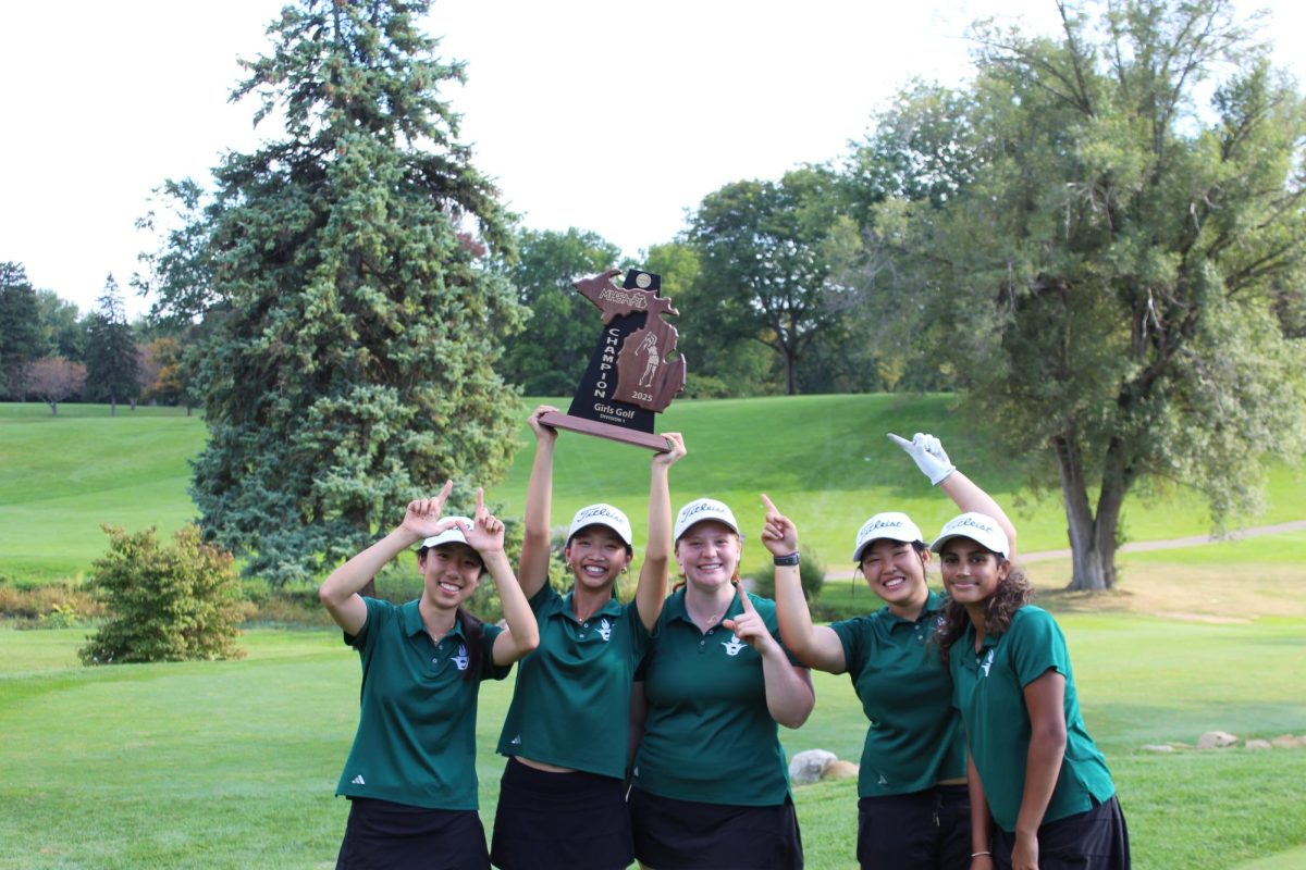 The Huron Women's Golf team celebrates with the trophy after winning Regionals. 