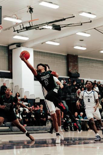 Going up for a physical “and-one” finish, junior Nate Sidney seeks a clutch bucket to take the lead against cross-town rival, Pioneer High School.