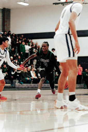 Driving toward the basket, senior Kinley Poole crosses his opponent and looks to score the go-ahead points for Huron in a tight matchup against Pioneer High School.
