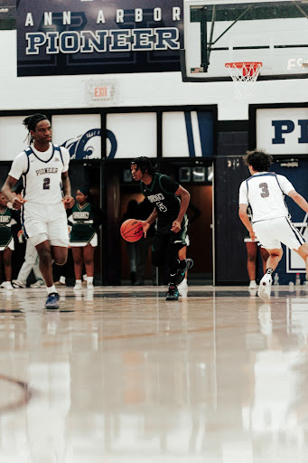 In the final minutes of the first half, senior Brandon Willis advances the ball up the floor in a tight matchup with Pioneer High School.