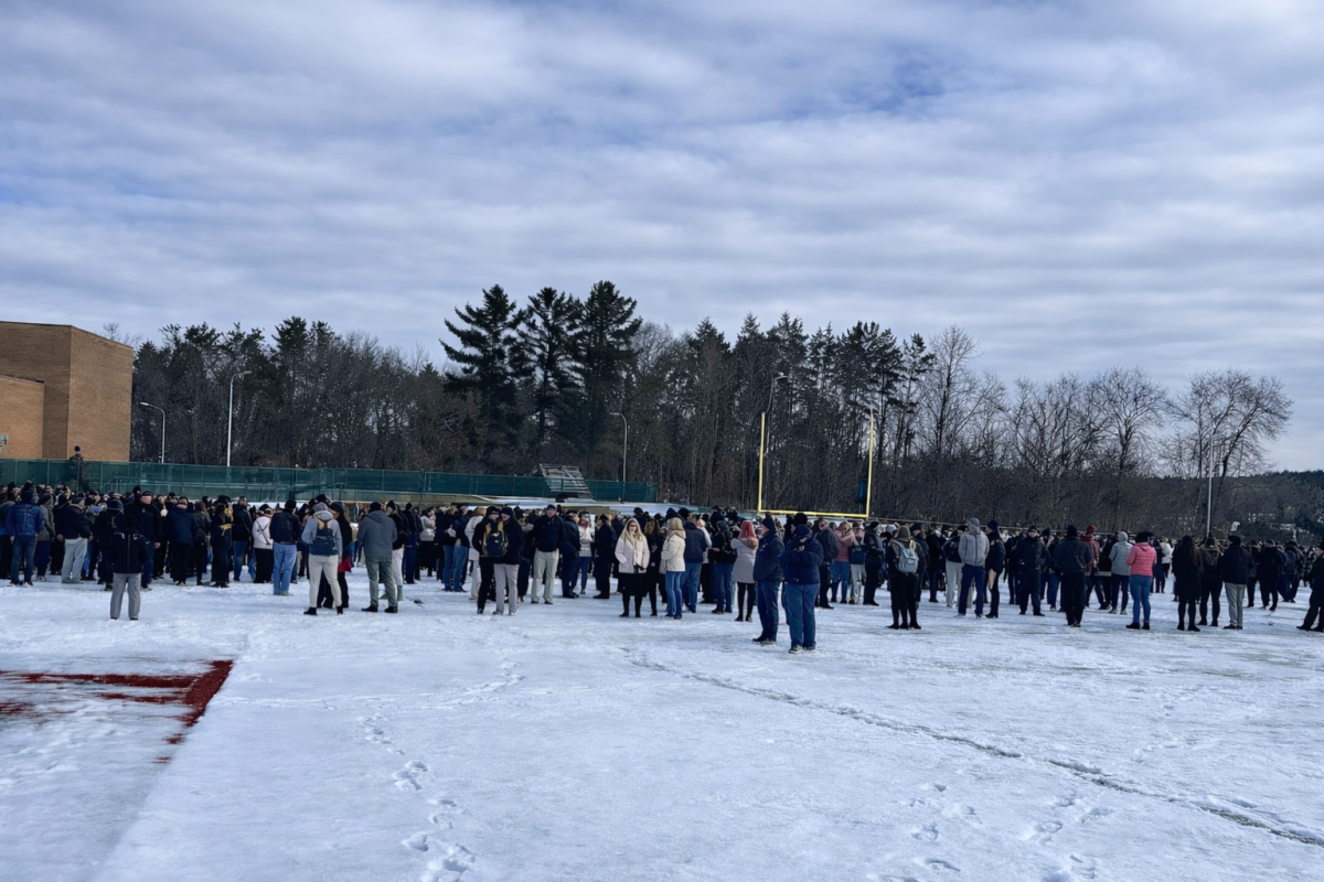 Students and staff gather on the football field after a fire alarm prompted a mid-morning evacuation.
