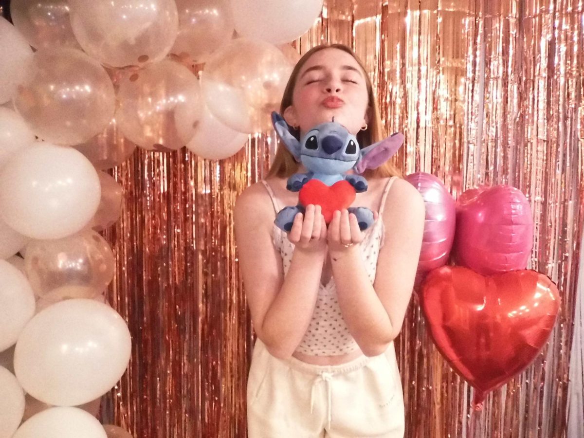 Roberts posing in front of a photo booth created by her and her friends for Galentine’s Day. Courtesy of Roberts. 
