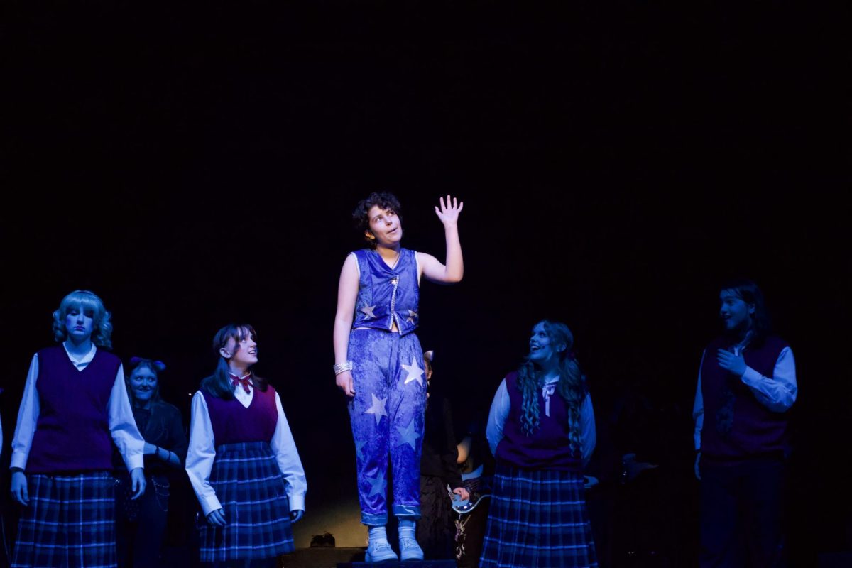 In a bright blue-and-white costume, McAllistor takes center stage for a solo during “Space Age Bachelor Man,” fully leaning into the character’s over-the-top, imagined world.