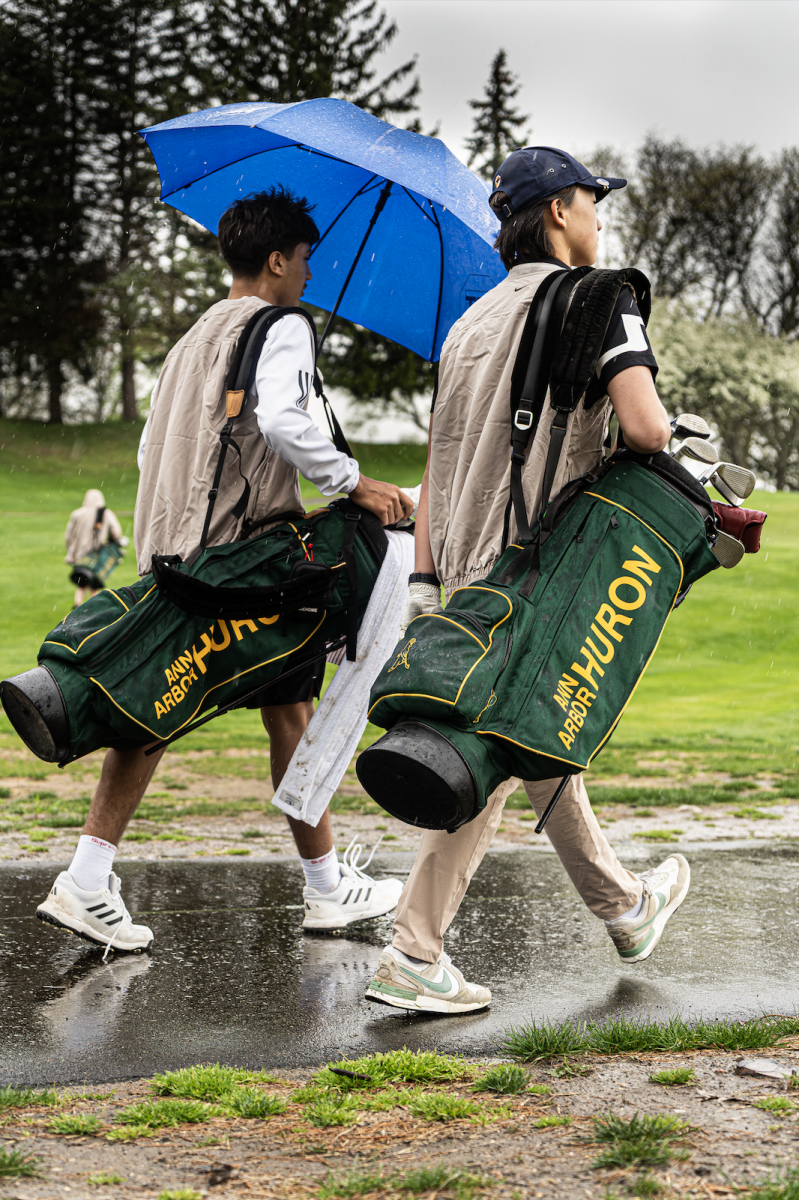 Junior Jetten Shah and freshman Seojin Han walk to their game during the rain. 