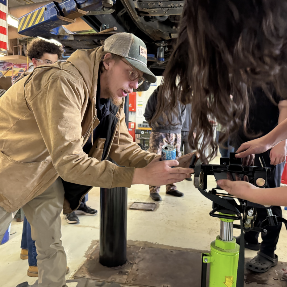 Chapman helping students remove an auto part. Courtesy of Chapman. 
